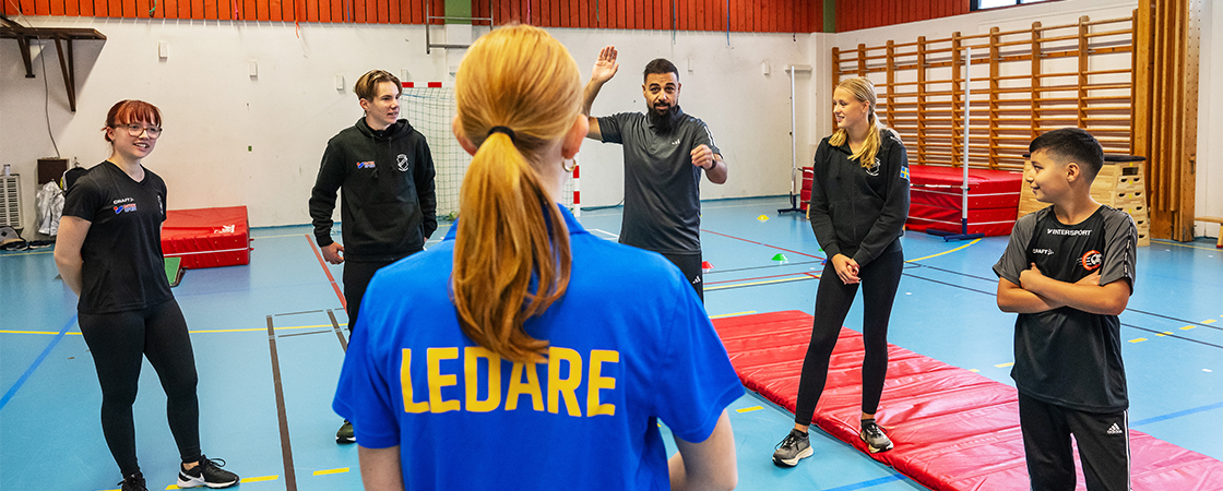 En idrottshall med fem aktiva och en ledare